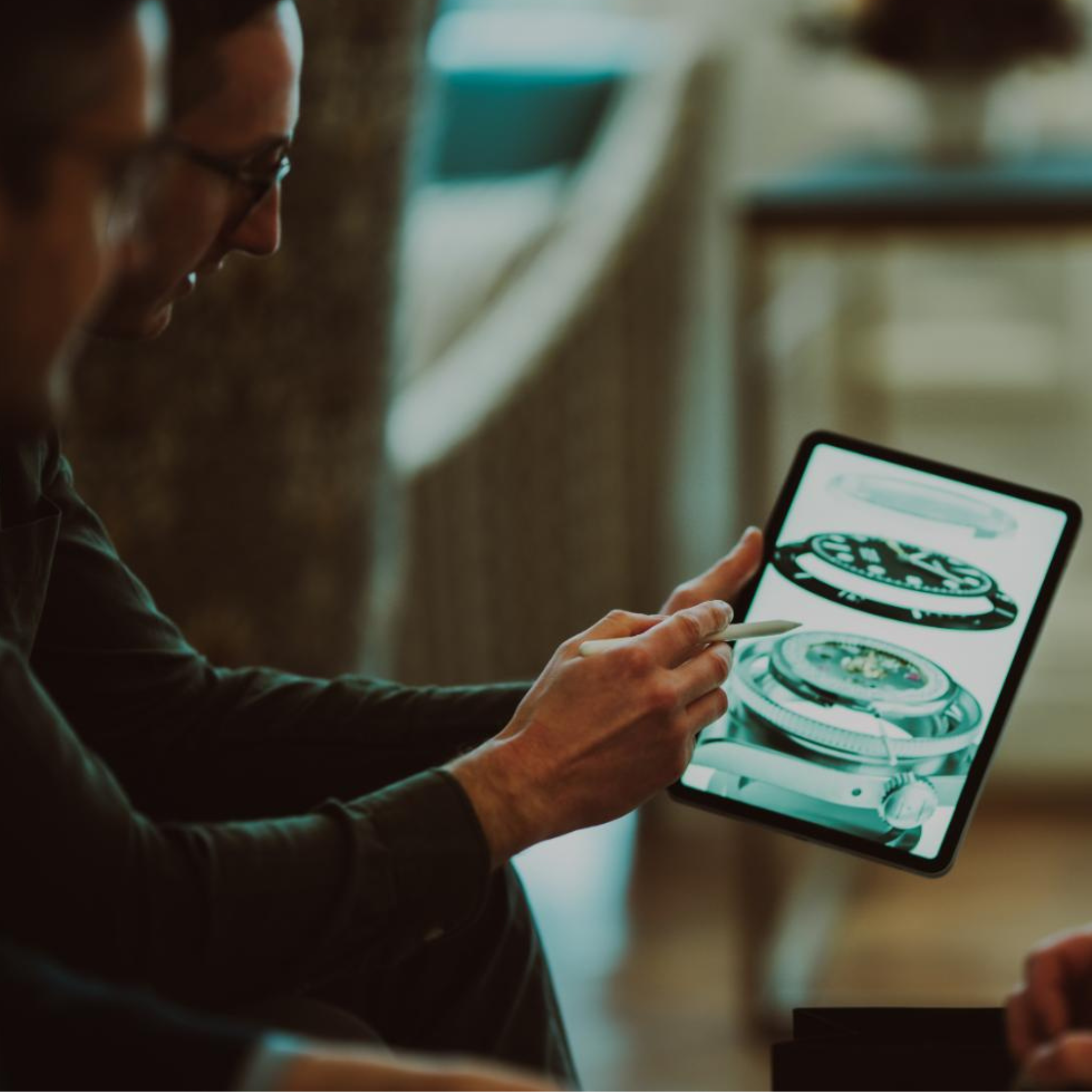Two people discussing a mechanical design displayed on a tablet.